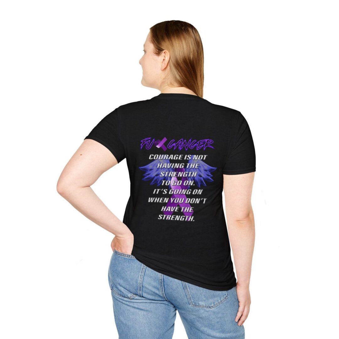 A woman wears the F*ck Cancer Ribbon Tee, a black t-shirt featuring the message "Courage is not having the strength to go on. It's going on when you don't have the strength." on the back.