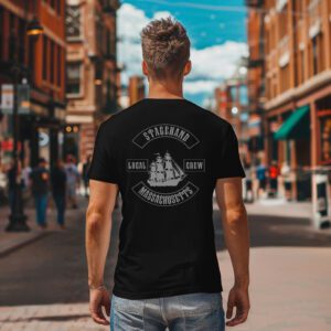 Seen from behind on a city street, a person wears the Massachusetts Stagehand Local Crew Tee—a black T-shirt featuring a ship and "Stagehand Local Crew Massachusetts" printed on the back.