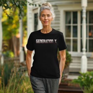 A woman with gray hair walks outside in the Generation X Tee and patterned pants, with a house and greenery in the background.